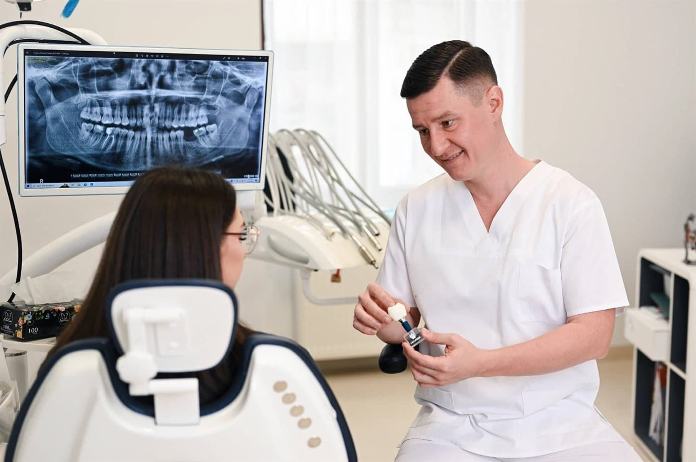Zahnarzt erklärt einem Patienten in unserer Partnerklinik ein Zahnimplantat